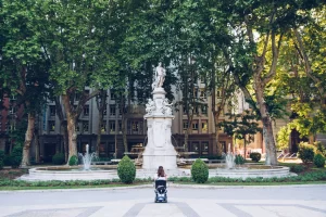 girl in a wheelchair facing a picturesque scene of statue