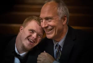 two men laughing sitting close to each other